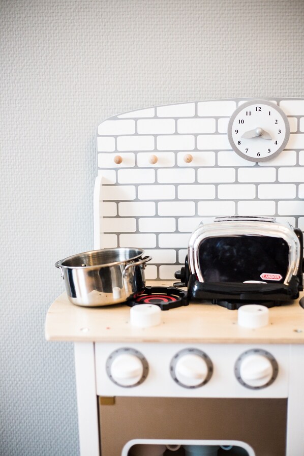 A kitchen with a white brick backsplash, a toaster, and a pot on the counter. - Centrally located, refurbished modern flat with views over the historic port (Honfleur)