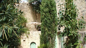A stone building with a green door, a window, and a stone wall.