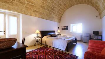 Relax in this serene bedroom with a large bed, bedside tables, and a comfortable chair.