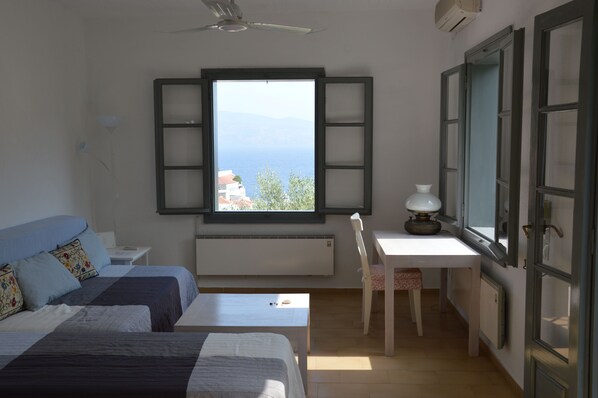 A bedroom with two beds, a desk, and a chair. - Hydra studio house with amazing harbour views (Hydra Town, Hydra)