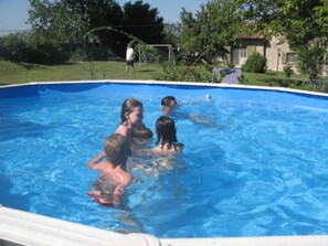 Ein Schwimmbecken mit spielenden Kindern im Wasser.