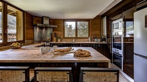 Eine moderne Küche mit einer großen Kochinsel, Edelstahlgeräten und Holzschränken.