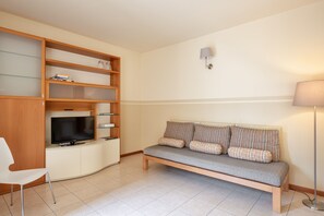 Relax in this stylish living room with a shelving unit, flat-screen TV, and comfortable sofa.