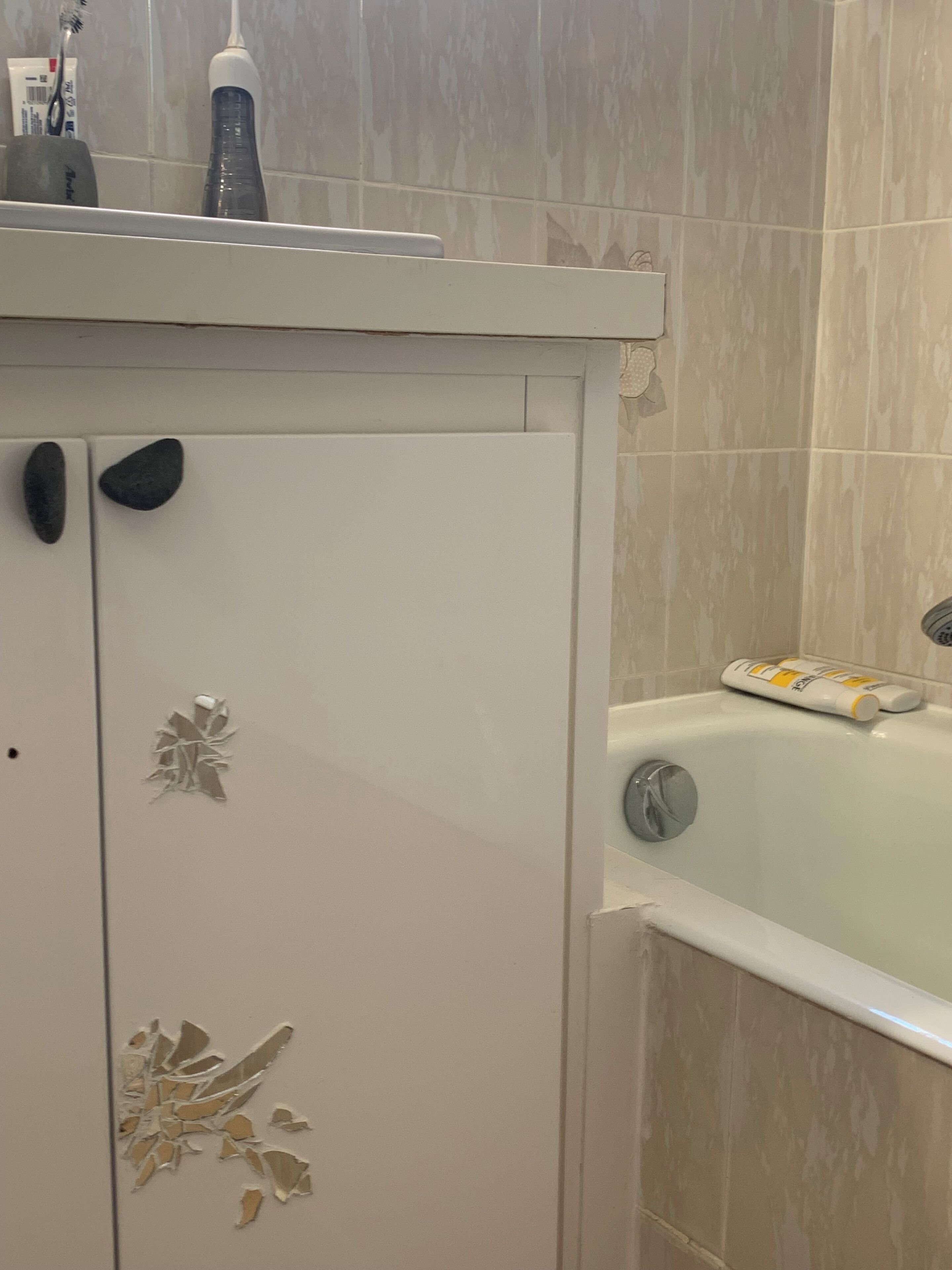Ein Badezimmer mit einem weißen Schrank, einer Badewanne und einer Toilette.