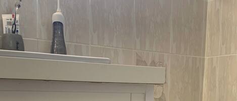 Ein Badezimmer mit einem weißen Schrank, einer Badewanne und einer Toilette.