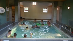 An indoor swimming pool with multiple lanes, a diving board, and a lifeguard chair. - GRAND FERME AVEC PISCINE INTERIEURE ET SALLE DES JEUX (Virargues)
