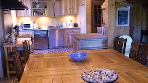 A wooden dining table with a bowl of corks in the center, surrounded by wooden chairs. - GRAND FERME AVEC PISCINE INTERIEURE ET SALLE DES JEUX (Virargues)