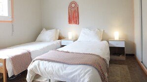 A bedroom with two single beds, a desk, and a wall-mounted dreamcatcher. - Collioure Seafront Apartment with Parking - Falco (Collioure)