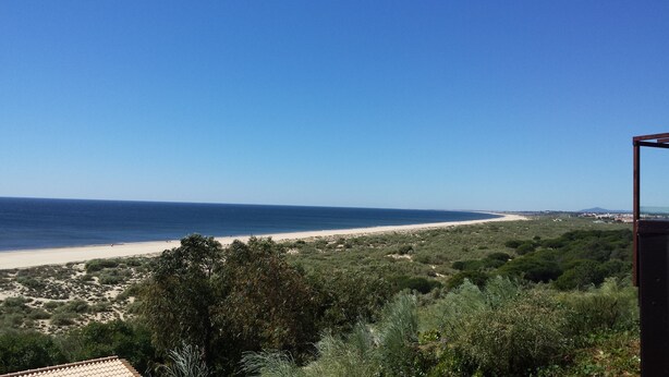 A coastal view with a beach, greenery, and a clear sky. - Cozy Villa, Praia Verde, Algarve (Praia Verde)
