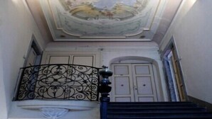 A grand staircase with a decorative ceiling mural, ornate black balustrade, and a classical architectural style. - Elegant, confortable flat in historical house, in the heart of Città Alta (Bergamo)