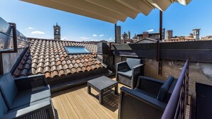 A rooftop terrace with a tiled roof, outdoor furniture, and a view of historic buildings in the background. - Elegant, confortable flat in historical house, in the heart of Città Alta (Bergamo)
