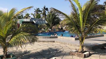 Una piscina al aire libre, sombrillas, tumbonas