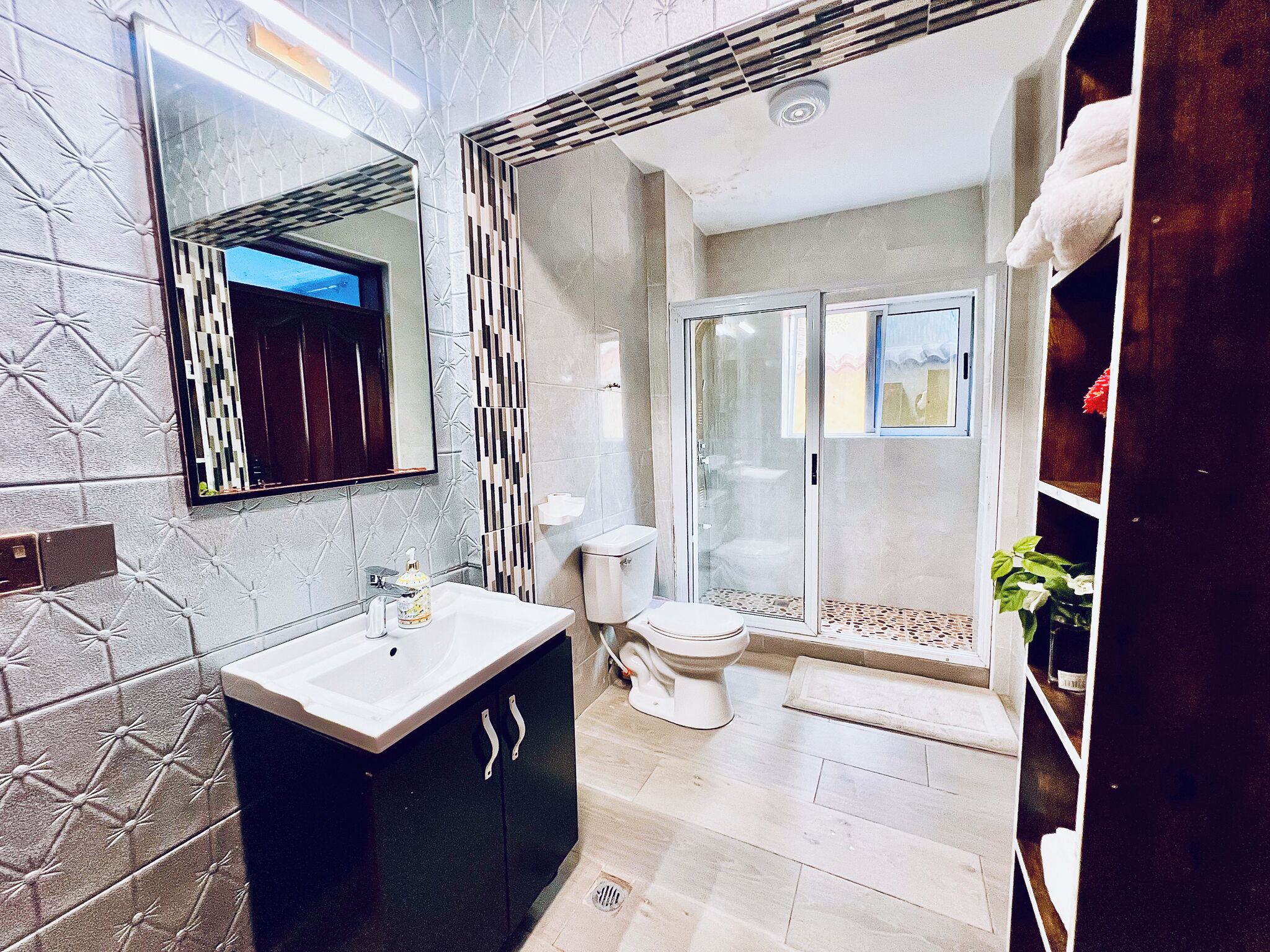 Ein modernes Badezimmer mit Waschtisch, Toilette und Duschbereich.