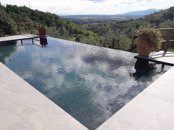 A clear pool with a view of a mountainous landscape.