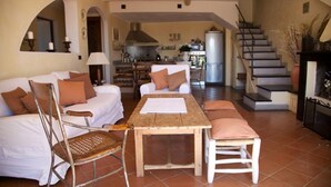 A spacious living area with a sofa set, a wooden table, and a chair. A staircase leads to a kitchen area in the background. - Villa With Fantastic Sea Views, Surrounded By Vineyards CITRA  009022-LT-0083 (Celle Ligure)
