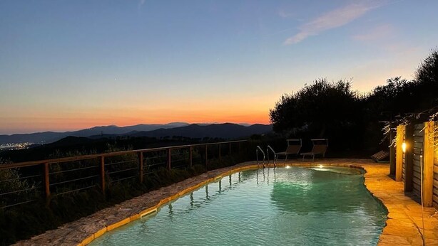 A swimming pool with a stone border, lounge chairs, and a view of the mountains at dusk. - Villa With Fantastic Sea Views, Surrounded By Vineyards CITRA  009022-LT-0083 (Celle Ligure)