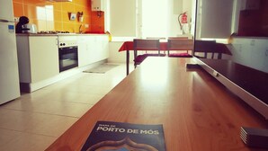 Een moderne keuken met een eethoek, met een houten tafel en een kaart van Porto de Mós.