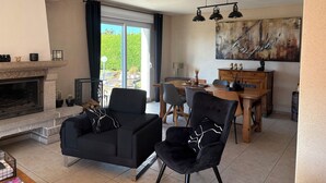 A spacious living area with a fireplace, a dining table, and comfortable seating.