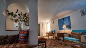Ein gemütliches Wohnzimmer mit einer Couch, einem Couchtisch, einem Essbereich mit Tisch und Stühlen und einer blauen Tür.
