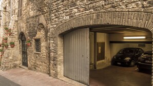 Un edificio de piedra con una puerta metálica cerrada y una pequeña ventana.