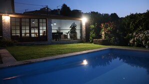 Una piscina amb una casa de pedra al fons.