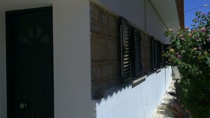 A white building with a dark door and window shutters.