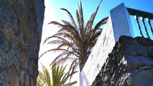 A staircase leading up to a building with a white facade and a stone wall on one side.