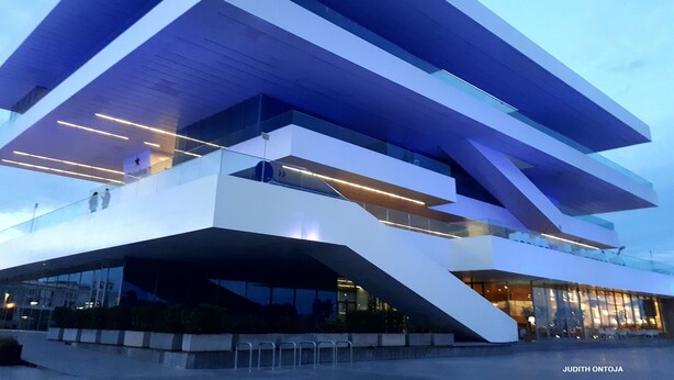 A modern building with a unique architectural design, featuring multiple levels and large glass windows. - Suitable. Bright 10 min from the BEACH walking and 3 min from the PORT (València)