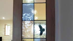 Una ventana de vitral con varios paneles, cada uno representando un ave en vuelo.
