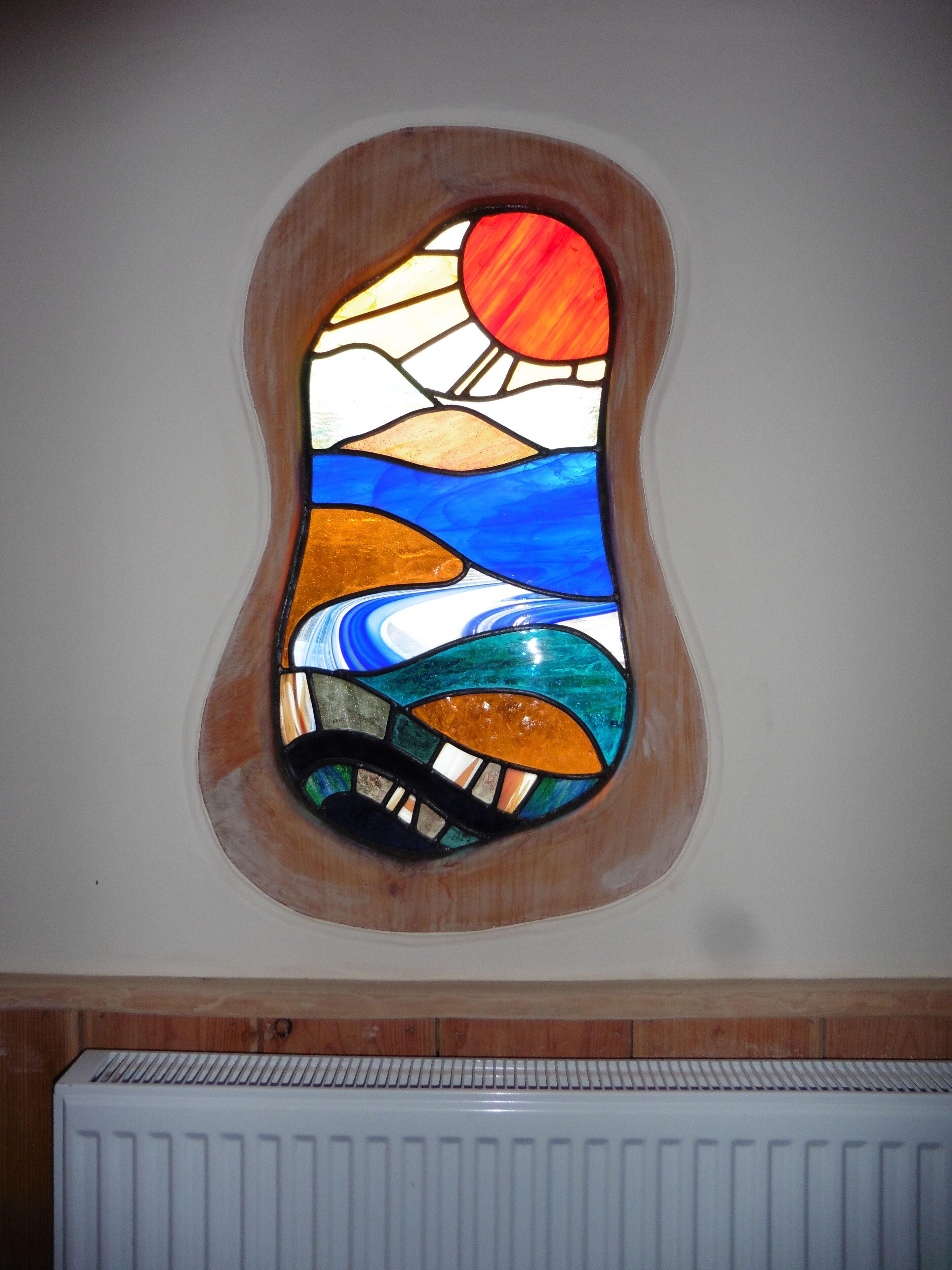 A stained glass window with a landscape design.