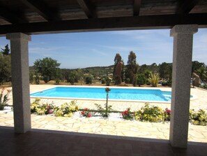 Una piscina amb rajoles de pedra i un jardí ple de flors.