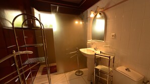 A bathroom with a white sink, mirror, and toilet. There is a metal rack with shelves and a ladder. The floor is tiled, and the walls are white. - GITE CLOSE TO PUY DU FOU 10 mins FROM VILLA MAGDALENA (Sèvremont)