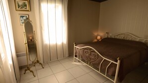 A bedroom with a bed, a mirror, and a window with curtains. - GITE CLOSE TO PUY DU FOU 10 mins FROM VILLA MAGDALENA (Sèvremont)