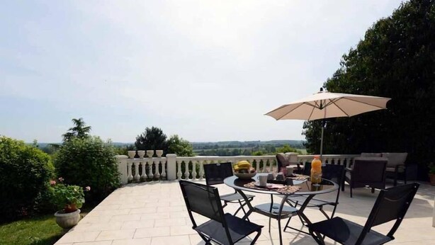 A patio with a round table and chairs, an umbrella, and a view of the landscape. - GITE CLOSE TO PUY DU FOU 10 mins FROM VILLA MAGDALENA (Sèvremont)