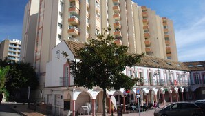 A multi-story hotel with balconies, a central courtyard, and a traditional facade.