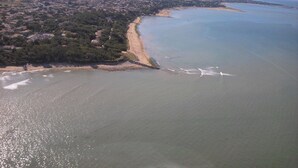 An aerial view of a coastal town with a beach, houses, and a clear sky. - Au Calme Stone house, large pool. near sea1,.5 km classified 4 stars (Saint-Pierre-D'oléron)