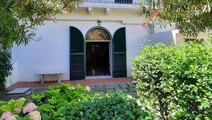 A two-story building with a white facade, green shutters, and a balcony with a railing. - Stately residence in the center, with garden (Vasto)