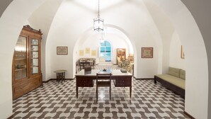 A dining area with a patterned floor, a wooden cabinet, a dining table with chairs, and a hanging light fixture. - Stately residence in the center, with garden (Vasto)