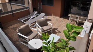 A rooftop terrace with lounge chairs, a table, and a small plant. - Spacious 2 bedroom apartment, large terrace, sea view, Paraiso II complex (Adeje)