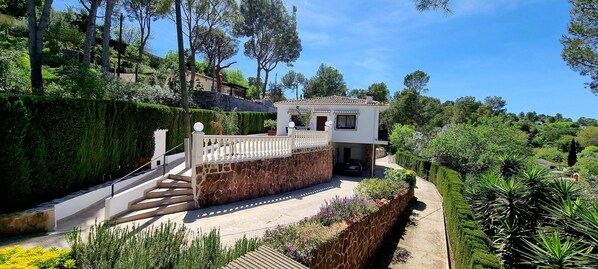 A house with a stone wall, a balcony, and a garden. - Wonderful Villa, Heated pool, Beautiful Town, Perfect for Families and Groups (Genovés)