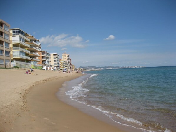 A beach with a row of multi-story buildings, some with balconies, and a clear view of the sea. - Wonderful Villa, Heated pool, Beautiful Town, Perfect for Families and Groups (Genovés)