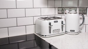Eine Küche mit einem Breville Toaster, einer Breville Kaffeemaschine und einer schwarzen Induktionskochplatte.