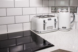 Une cuisine équipée d’un grille-pain Breville, d’une machine à café Breville et d’une plaque de cuisson à induction noire.