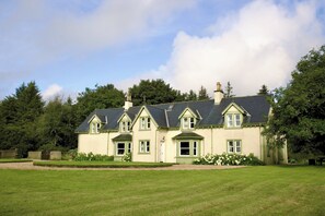 A large, two-story house with a symmetrical facade, multiple windows, and a well-maintained lawn in front. - Lagafater Lodge (Stranraer)