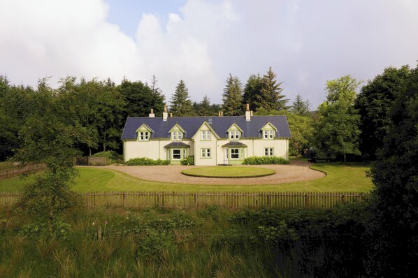 A large, two-story house with a symmetrical facade, a central entrance, and a circular driveway. - Lagafater Lodge (Stranraer)