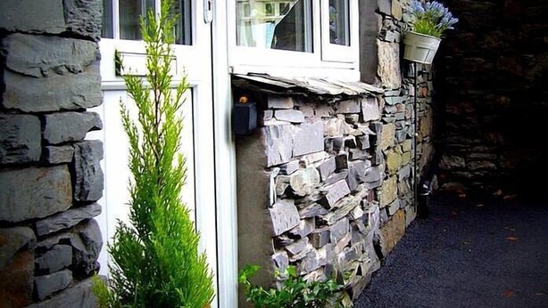 A stone building with a window and potted plants. - Stylish & Contemporary 5 * Fully Renovated Luxurious Holiday Cottage Ambleside  (Ambleside)