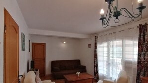 Ein Wohnzimmer mit einer Couch, zwei Sesseln, einem Couchtisch und einer Chandelier.