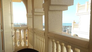 A balcony with a table set for breakfast, including croissants, orange juice, and coffee. - Luxery apartment "SEAGULL" - Family friendly - 2 bedrooms (max.4 pers.) (El Ejido)