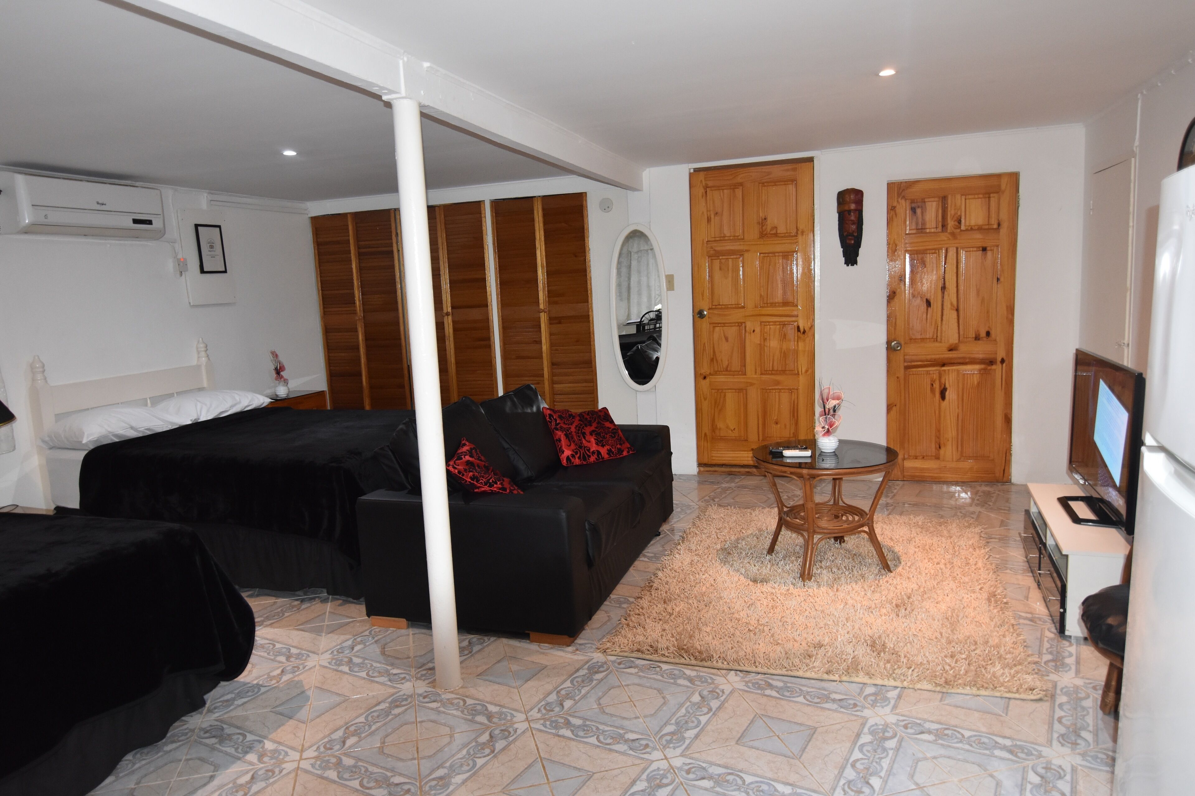 A bedroom with a bed, a sofa, a TV, and a wardrobe.