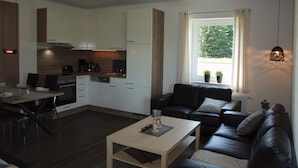 Un appartement moderne comprenant une cuisine, un coin repas et un salon.